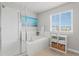 Serene bathroom with soaking tub, glass enclosed shower, and a bright window view at 7380 S Shady Grove Way, Aurora, CO 80016
