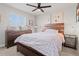 Stylish bedroom with wood furnishings, a patterned comforter, and a bright window view at 7380 S Shady Grove Way, Aurora, CO 80016