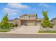 Two-story brick home with a three car garage, a well-manicured lawn and mature trees at 7380 S Shady Grove Way, Aurora, CO 80016