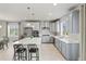 Spacious kitchen with grey cabinets, a large island with seating, and stainless steel appliances at 7380 S Shady Grove Way, Aurora, CO 80016
