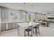 Bright kitchen featuring grey cabinets, a large island with seating, and stainless steel appliances at 7380 S Shady Grove Way, Aurora, CO 80016