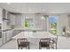 Modern kitchen with grey cabinets, a large island with seating, and bright lighting at 7380 S Shady Grove Way, Aurora, CO 80016