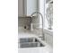 Close-up of a stainless steel kitchen sink with a modern faucet and bright countertop at 7380 S Shady Grove Way, Aurora, CO 80016