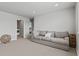 Cozy living room features a comfortable gray sofa and carpeted flooring with a view to the laundry room at 7380 S Shady Grove Way, Aurora, CO 80016