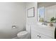 Features a white vanity, toilet, decorative mirror, and coastal-inspired artwork at 7380 S Shady Grove Way, Aurora, CO 80016