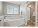 Bright bathroom featuring a soaking tub, large window, and walk-in shower at 2252 S Yosemite Cir, Denver, CO 80231