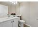 Clean half bathroom featuring a white vanity, quartz countertop, and stylish fixtures in a neutral color palette at 2252 S Yosemite Cir, Denver, CO 80231