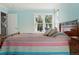 Bright bedroom with a large window and a colorful striped quilt on the bed at 2252 S Yosemite Cir, Denver, CO 80231