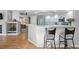 Kitchen with breakfast bar overlooking the living room, featuring stainless steel appliances and white cabinetry at 2252 S Yosemite Cir, Denver, CO 80231
