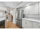 Galley kitchen with stainless steel refrigerator, white cabinets, and ample counter space for meal preparation at 2252 S Yosemite Cir, Denver, CO 80231