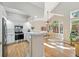 Bright kitchen features white cabinets, stainless steel appliances, and a breakfast bar overlooking the dining area at 2252 S Yosemite Cir, Denver, CO 80231