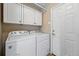 Laundry room features washer, dryer, and overhead cabinets for storage at 2252 S Yosemite Cir, Denver, CO 80231