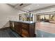 Stylish bar area with dark wood cabinets, stone backsplash, and a staircase leading to another level at 7113 Echo Hills Club Rd, Larkspur, CO 80118
