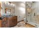 Modern bathroom features marble countertops, a shower, and stone floors at 7113 Echo Hills Club Rd, Larkspur, CO 80118
