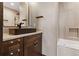 Elegant bathroom with a dark wood vanity, a rectangular sink, and a tiled shower and tub at 7113 Echo Hills Club Rd, Larkspur, CO 80118