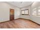 Bright bedroom with hardwood floors, a large window, and wood trim around the baseboards and doorframe at 7113 Echo Hills Club Rd, Larkspur, CO 80118