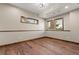 Unfurnished room features hardwood floors and two windows with wood trim at 7113 Echo Hills Club Rd, Larkspur, CO 80118