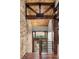 Stunning entryway with stone walls, wooden beams, and breathtaking mountain views through the window at 7113 Echo Hills Club Rd, Larkspur, CO 80118