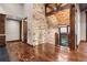 Elegant foyer featuring hardwood floors, stone accent wall, and wooden beam architecture at 7113 Echo Hills Club Rd, Larkspur, CO 80118