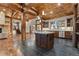 Expansive kitchen with an island, wooden beams, and stainless steel appliances perfect for entertaining at 7113 Echo Hills Club Rd, Larkspur, CO 80118
