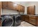 Functional laundry room features cabinets and modern washer and dryer at 7113 Echo Hills Club Rd, Larkspur, CO 80118