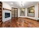 Bright living room with hardwood floors, a fireplace and built-in shelving at 7113 Echo Hills Club Rd, Larkspur, CO 80118