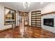 Bright living room with hardwood floors, a fireplace and built-in shelving at 7113 Echo Hills Club Rd, Larkspur, CO 80118