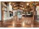 Open-concept living area with hardwood floors, a stone fireplace, and a stunning wood-beam ceiling at 7113 Echo Hills Club Rd, Larkspur, CO 80118