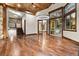 Bright and airy living room with hardwood floors, wooden beams, and access to outdoor spaces at 7113 Echo Hills Club Rd, Larkspur, CO 80118