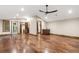 Spacious living room featuring hardwood floors and a wet bar with custom wood trim and recessed lighting at 7113 Echo Hills Club Rd, Larkspur, CO 80118