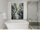 Elegant bathroom featuring a freestanding tub, glass-enclosed shower, modern art, and neutral color palette at 1401 Delgany St # 204, Denver, CO 80202