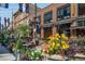 Charming street view with colorful planters, inviting outdoor dining, and a variety of shops and restaurants at 1401 Delgany St # 204, Denver, CO 80202