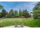 Lush backyard featuring mature trees and a fire pit area at 5 Hillside Dr, Wheat Ridge, CO 80215