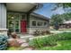 Inviting gray home entrance featuring modern windows, a red door, and well-maintained landscaping at 5 Hillside Dr, Wheat Ridge, CO 80215
