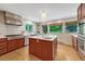 Spacious kitchen featuring stainless steel appliances, custom cabinets, and a large kitchen island at 5 Hillside Dr, Wheat Ridge, CO 80215