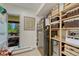 Functional kitchenette with a black refrigerator, wooden shelves, and natural light streaming through the door to the deck at 5 Hillside Dr, Wheat Ridge, CO 80215