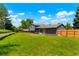 Backyard with a well-maintained lawn, partially fenced perimeter, and exterior view of the home at 16322 E Idaho Pl, Aurora, CO 80017