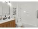 Clean bathroom featuring a wood vanity, updated fixtures, and a shower-tub combination at 16322 E Idaho Pl, Aurora, CO 80017