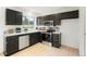 Modern kitchen with black cabinets, stainless steel appliances, and bright countertops for cooking prep at 16322 E Idaho Pl, Aurora, CO 80017