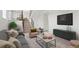 Comfortable living room with modern decor, including a gray sofa, soft-colored armchair, and sleek furniture at 16322 E Idaho Pl, Aurora, CO 80017