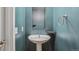 Cozy bathroom with a pedestal sink, stylish mirror, and a teal wall at 2335 Walnut St # 10, Denver, CO 80205
