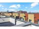 Rooftop view of condos with distant mountain view under a partly cloudy blue sky at 2335 Walnut St # 10, Denver, CO 80205