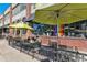 Charming outdoor seating at Denver Central Market, featuring brick facade, rainbow flag and inviting patio umbrellas at 2335 Walnut St # 10, Denver, CO 80205