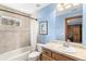 A bathroom with a bathtub, toilet, sink, and light-blue painted walls at 2411 S Garfield St, Denver, CO 80210
