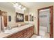 Bright bathroom features a double vanity and tub with glass shower doors at 2411 S Garfield St, Denver, CO 80210