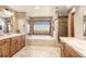 This bright bathroom has a double vanity, bathtub, and tiled walk-in shower at 2411 S Garfield St, Denver, CO 80210