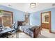 This light-blue bedroom has a bed, desk, and view of a bathroom with wood cabinets and trim at 2411 S Garfield St, Denver, CO 80210