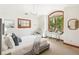Bright bedroom with a large arched window, natural light, and stylish decor at 2411 S Garfield St, Denver, CO 80210