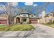 Charming two-story home featuring a well-manicured lawn, arched entryway, and a two-car garage for convenience at 2411 S Garfield St, Denver, CO 80210