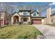 Traditional two-story home with a well-kept lawn, lush trees, and a wide driveway for easy parking at 2411 S Garfield St, Denver, CO 80210